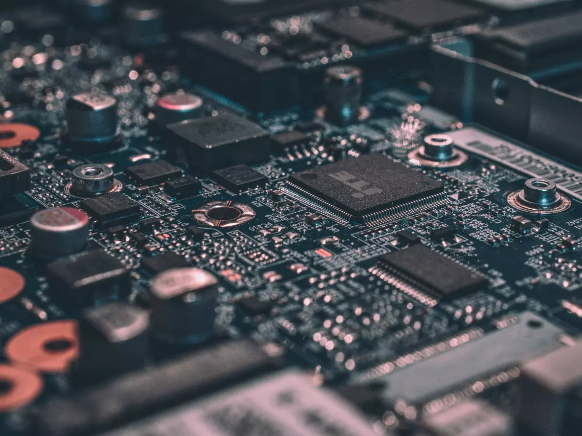 A close-up shot of a circuit board with various components, including a chip in the center.